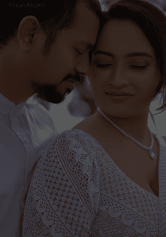 Couple smiling at each other, the bride holding a bouquet