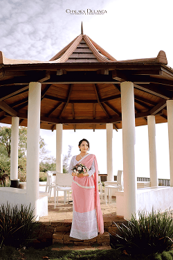 Bride standing inside a white-columned garden pavilion