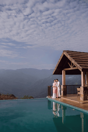 Couple on a hillside pavilion beside an infinity pool